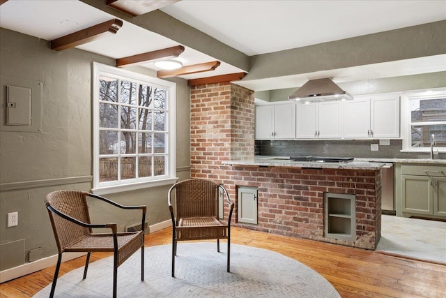 kitchen with appliances with stainless steel finishes, beam ceiling, extractor fan, decorative backsplash, and light wood-type flooring