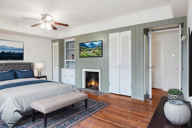 bedroom featuring wood-type flooring, ornamental molding, and ceiling fan