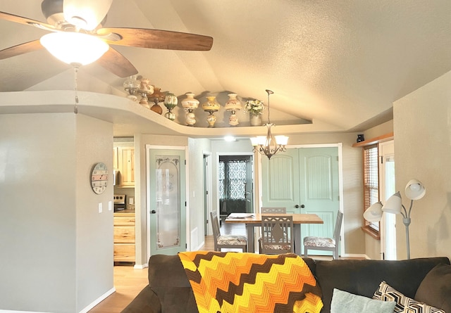 dining space with light hardwood / wood-style flooring, vaulted ceiling, a textured ceiling, and plenty of natural light