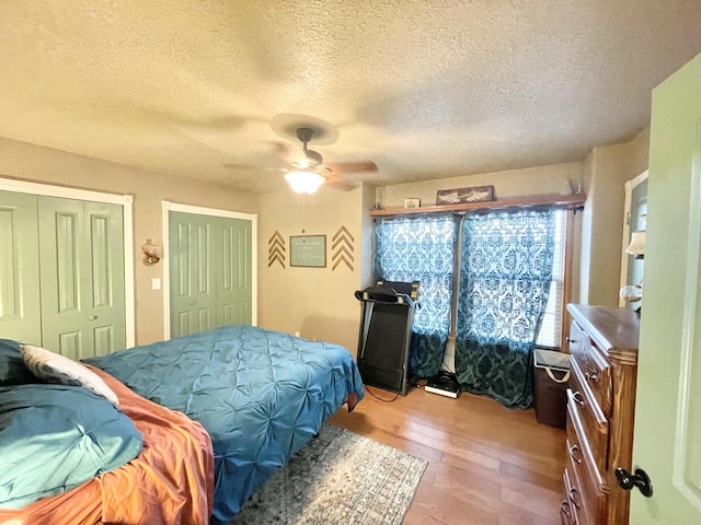 bedroom with a textured ceiling, ceiling fan, and light hardwood / wood-style flooring