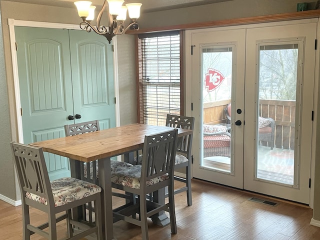 dining space with wood-type flooring, french doors, and plenty of natural light