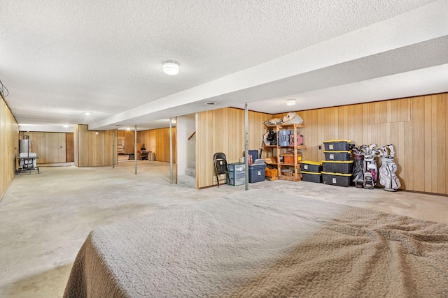 basement featuring wooden walls and a textured ceiling