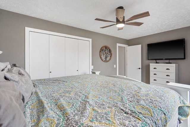 bedroom with ceiling fan, a closet, and a textured ceiling