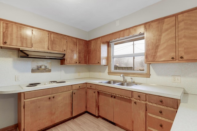 kitchen with tasteful backsplash, sink, white stovetop, and light wood-type flooring