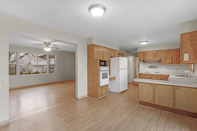 kitchen featuring sink, ceiling fan, kitchen peninsula, white appliances, and light hardwood / wood-style floors