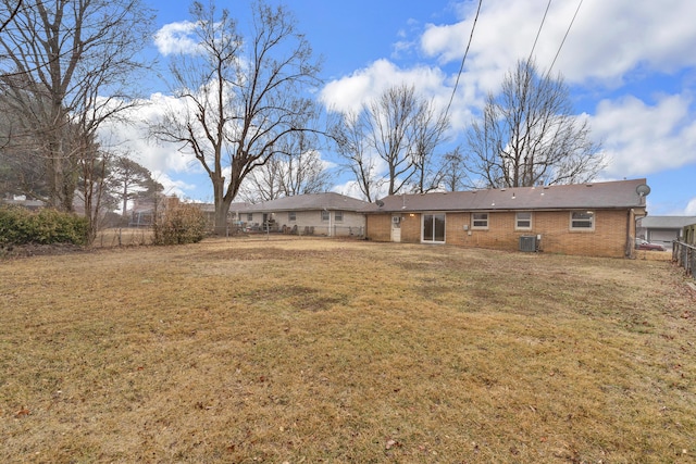 back of property featuring central AC unit and a yard