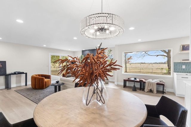 dining area featuring light wood-type flooring and a chandelier