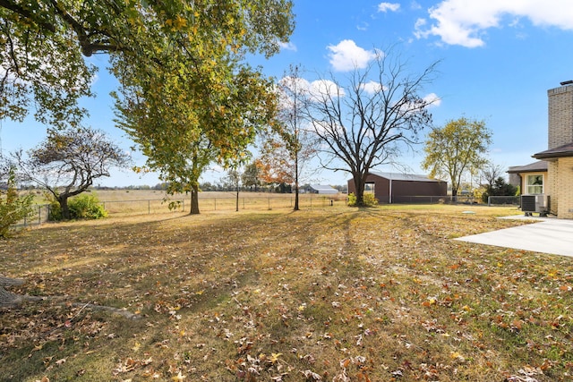 view of yard featuring a rural view, a patio, and central air condition unit