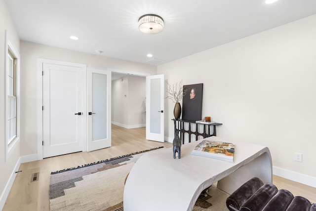 home office with light hardwood / wood-style flooring