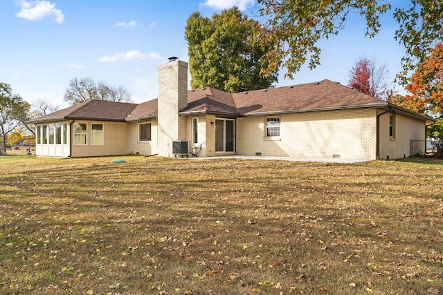 rear view of house featuring central AC unit, a lawn, a sunroom, and a patio