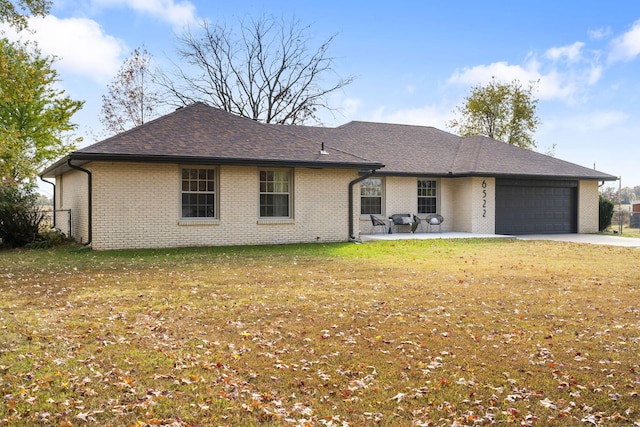 single story home featuring a garage, a patio area, and a front yard