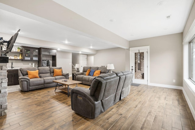 living room with hardwood / wood-style floors and sink