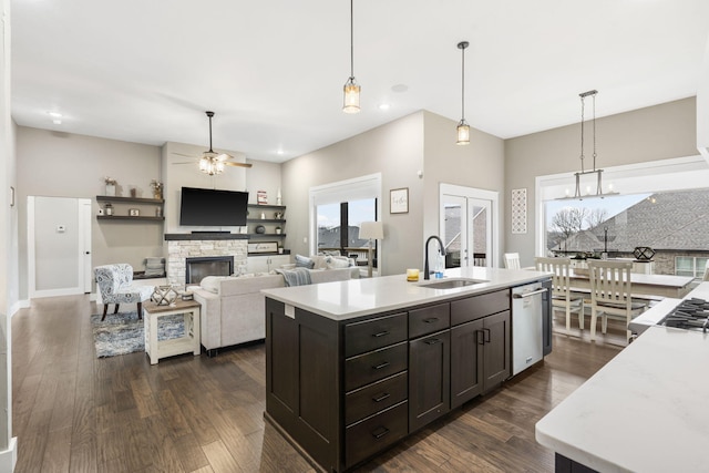 kitchen featuring sink, decorative light fixtures, an island with sink, and dishwasher