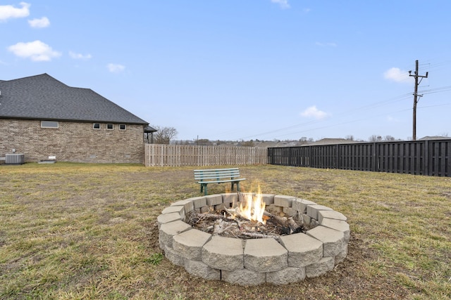 view of yard featuring cooling unit and an outdoor fire pit