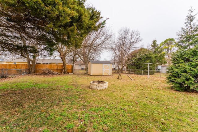 view of yard with a storage shed and an outdoor fire pit