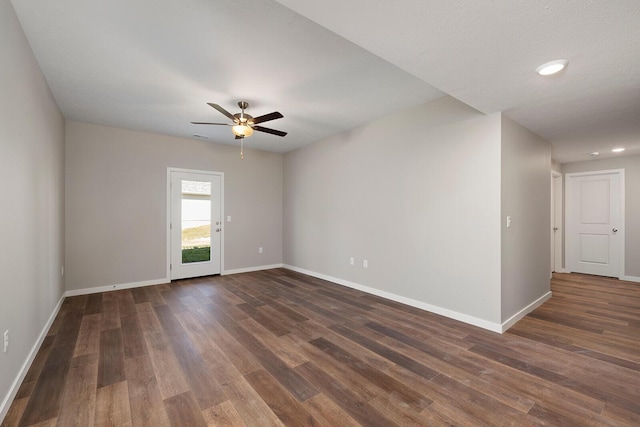 unfurnished room featuring dark wood-type flooring and ceiling fan