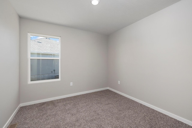 carpeted empty room featuring a textured ceiling