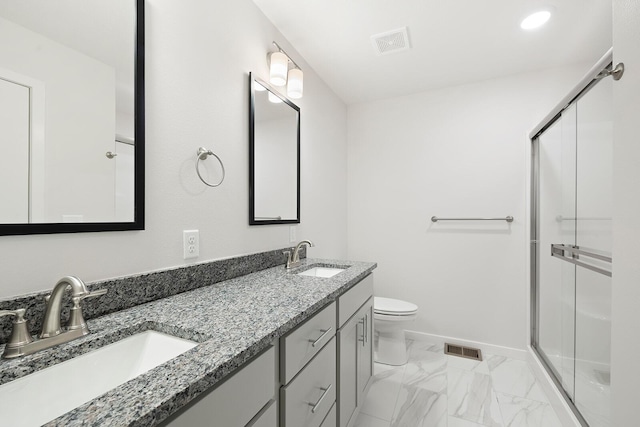 bathroom featuring vanity, toilet, and an enclosed shower