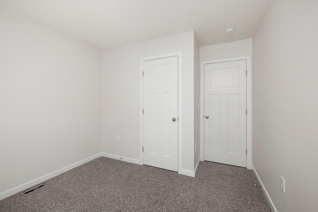 unfurnished bedroom with dark carpet