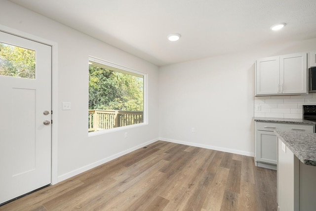 unfurnished dining area with light hardwood / wood-style floors and a healthy amount of sunlight