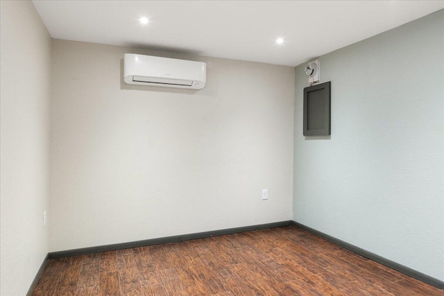 basement featuring dark hardwood / wood-style flooring, a wall unit AC, and electric panel