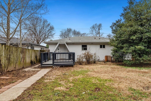 back of house with a lawn and a deck