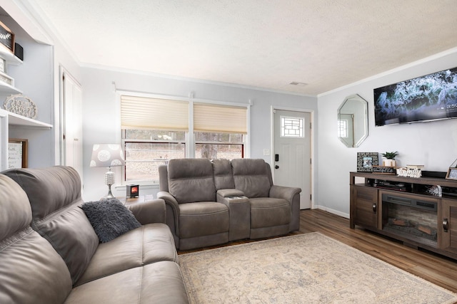 living room featuring crown molding, hardwood / wood-style flooring, and a textured ceiling