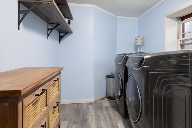 washroom with crown molding, wood-type flooring, washer and dryer, and a textured ceiling