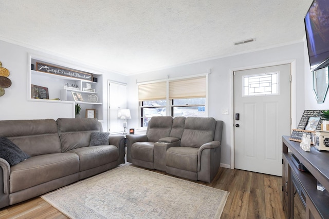 living room featuring crown molding, dark hardwood / wood-style floors, and a textured ceiling