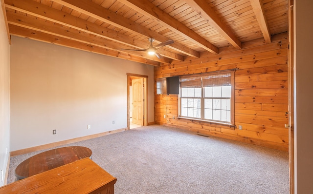 unfurnished room with beamed ceiling, wood ceiling, carpet floors, and wood walls