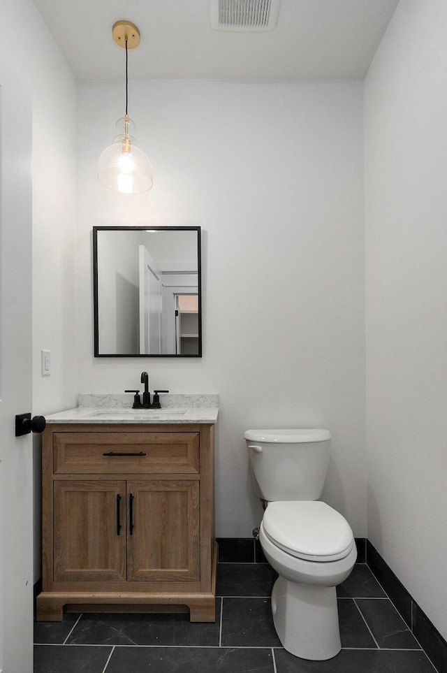 bathroom featuring tile patterned flooring, vanity, and toilet