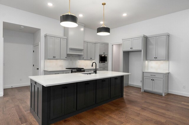 kitchen with sink, gray cabinetry, a kitchen island with sink, stainless steel appliances, and decorative light fixtures