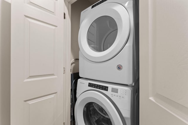 washroom featuring stacked washer and clothes dryer