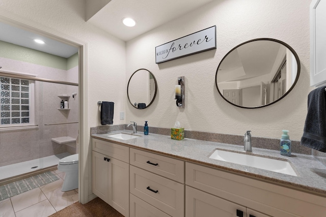 bathroom with vanity, a shower with shower door, tile patterned floors, and toilet