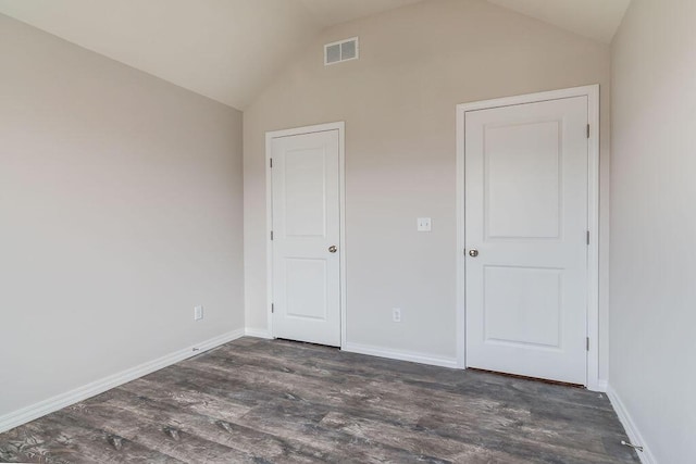 unfurnished bedroom with dark wood-type flooring and lofted ceiling