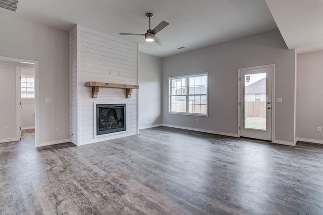 unfurnished living room with ceiling fan, a large fireplace, and dark hardwood / wood-style flooring