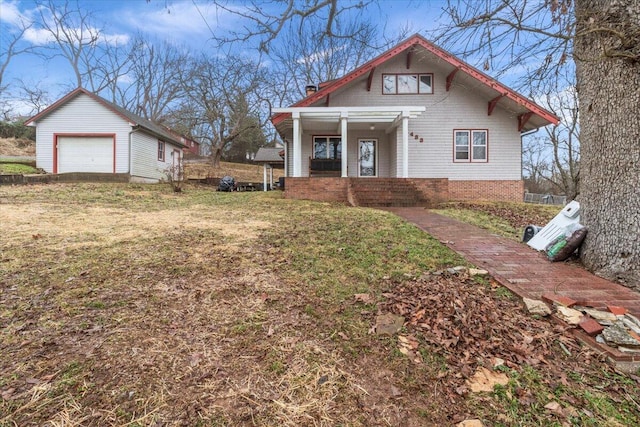 view of front of property with an outbuilding, a porch, a garage, and a front yard