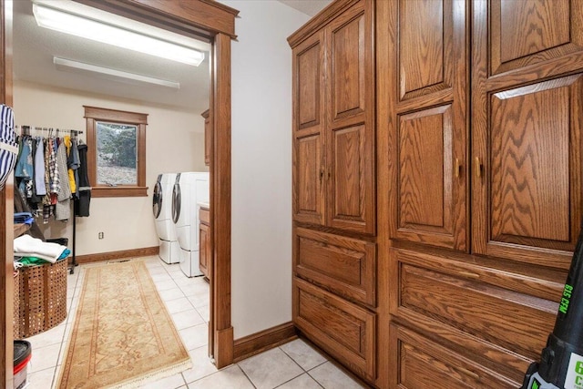 laundry area featuring light tile patterned floors, cabinets, and independent washer and dryer