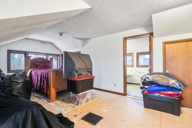 bedroom with vaulted ceiling and a textured ceiling
