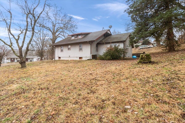 rear view of property featuring a yard and central AC