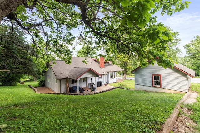 433 S Hill St, West Plains, MO 65775 - back of property with a lawn, a shingled roof, a chimney, and central AC unit