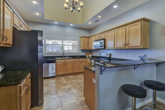 kitchen featuring hanging light fixtures, a breakfast bar area, sink, and appliances with stainless steel finishes