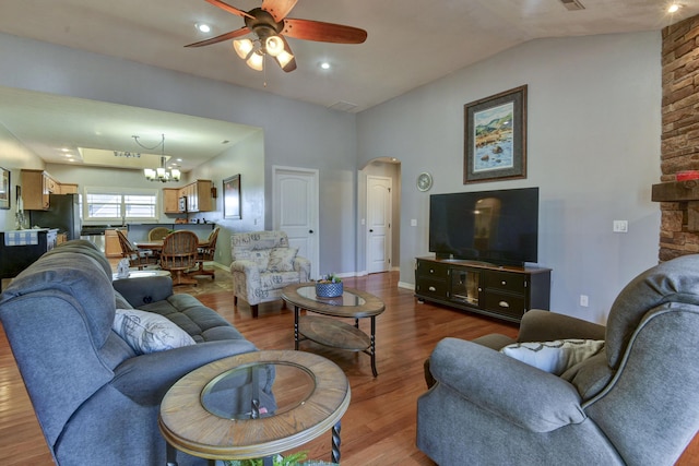 living room with hardwood / wood-style flooring, vaulted ceiling, and ceiling fan with notable chandelier