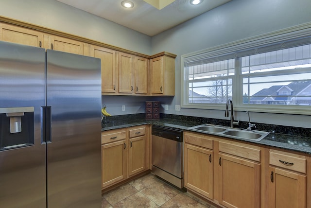 kitchen with appliances with stainless steel finishes, sink, and dark stone counters