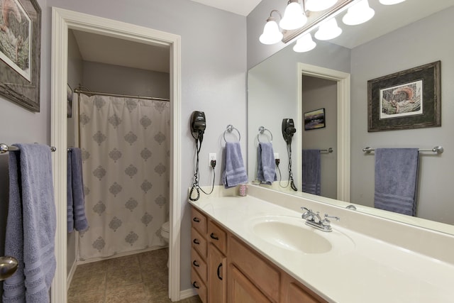 bathroom with vanity, toilet, and curtained shower