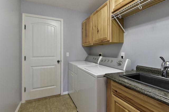 laundry area featuring cabinets, separate washer and dryer, and sink