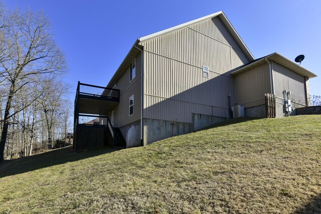 view of side of home with a yard and central air condition unit