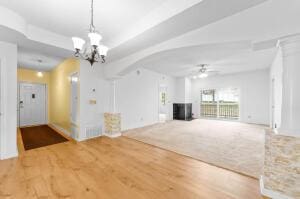 unfurnished living room featuring hardwood / wood-style flooring and ceiling fan with notable chandelier