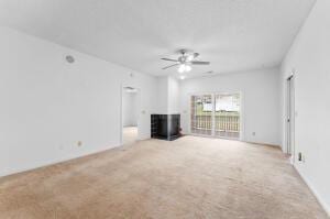 unfurnished living room featuring light carpet and ceiling fan