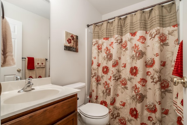 bathroom featuring vanity, curtained shower, and toilet